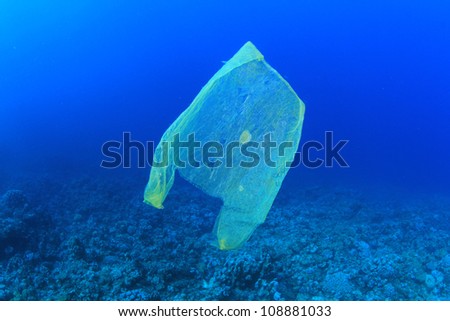 Plastic rubbish bag pollutes a coral reef in the ocean