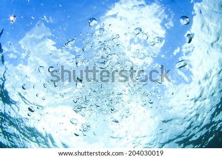 Bubbles underwater in blue sea