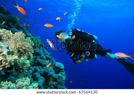 Young woman scuba diving on a beautiful coral reef