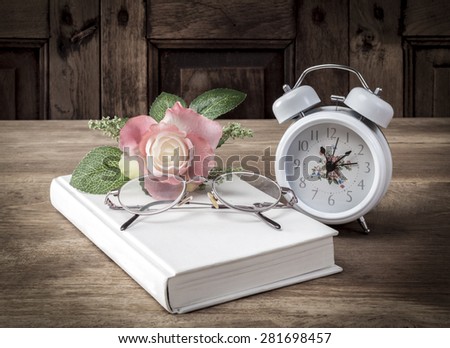 Vintage, book, glasses and watches, on the background of a wooden wall