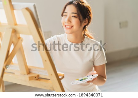 Young girl sitting on the floor learning to draw by herself
