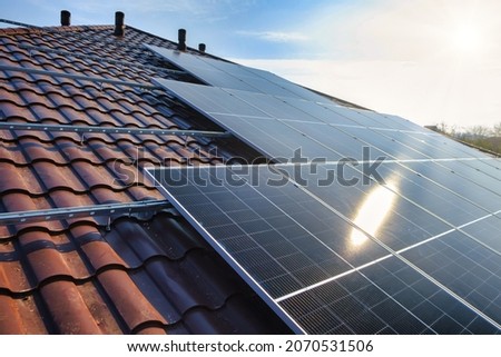 Photovoltaic panels on the roof . Roof Of Solar Panels. View of solar panels (solar cell) in the roof house with sunlight Stock fotó © 