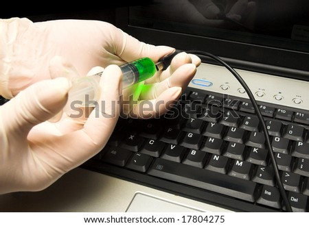 Anti-Virus.  A concept photo illustrating a laptop computer being inoculated with green anti-virus serum through a syringe.
