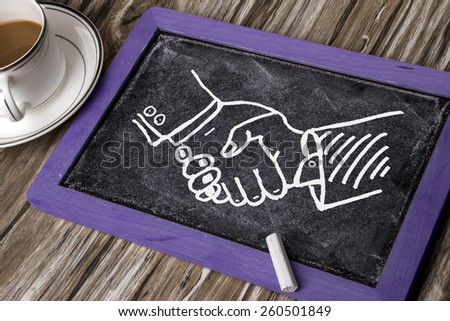 business handshake deal drawn on blackboard