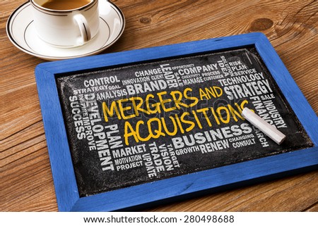 mergers and acquisitions concept with business word cloud handwritten on blackboard