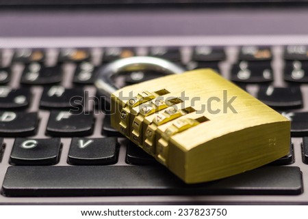 Closed or locked combination padlock on a laptop keyboard symbolizing data and computer security