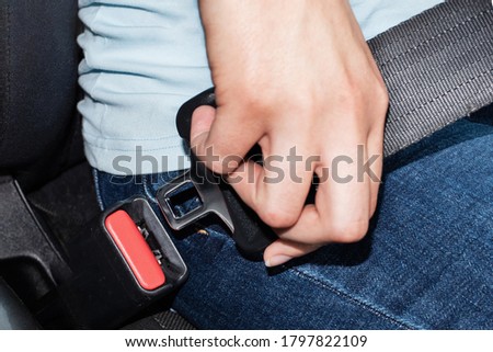 Close-up of a caucasian female hand holding a seat belt buckle for fastening in a car. Car safety concept 商業照片 © 