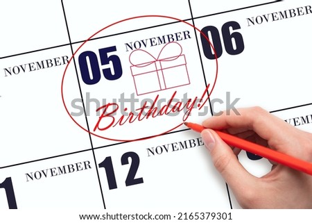 5th day of November. The hand circles the date on the calendar 5 November, draws a gift box and writes the text Birthday. Holiday. Autumn month, day of the year concept. Foto d'archivio © 