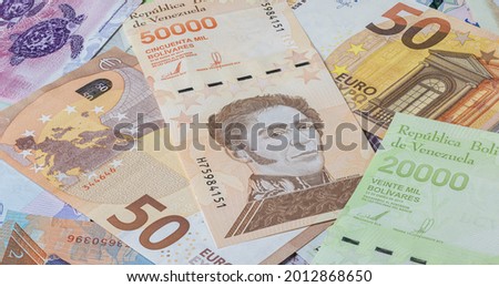 50 Euro in a big pile of Bolivar banknotes. Many Bolivares bills lie on top of each other. Bunch of money of the almost bankrupt country of Venezuela . Currency of the republic Venezuela between Euros Imagine de stoc © 