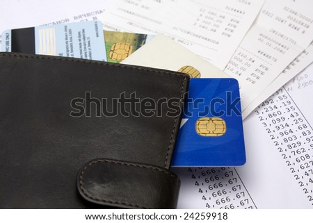 Wallet with credit cards on bills and checks