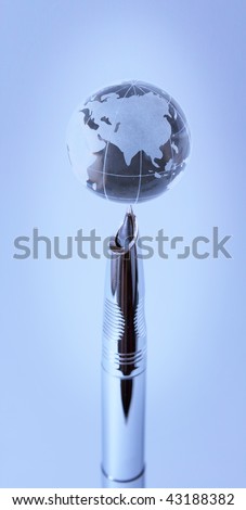 Crystal globe on nib of fountain pen in blue light