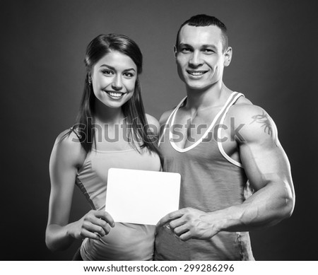 Man with muscular tattooed hand and woman holding blank notice board