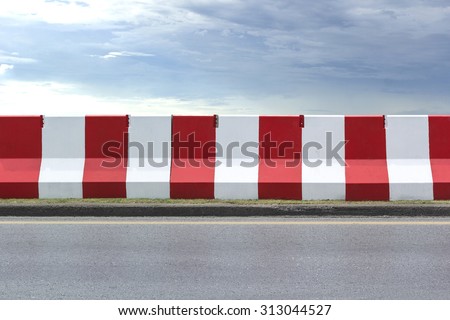 Red and white concrete barriers blocking the road