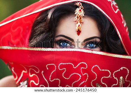 Indian woman bride, beautiful indian girl traditional sari costume covered face with veil, India. Girl bollywood dancer in Sari. Arabian bellydancer. Indian wedding makeup