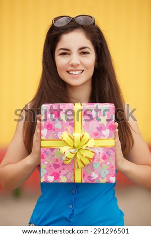 Happy smiling woman with gift box, beautiful girl with birthday gifts outdoor, beautiful female at birthday party with present, joyful lady hold gifts outdoor portrait, instagram style color filter