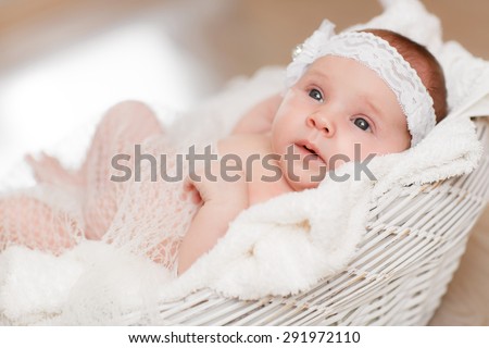 Cute newborn baby girl sleeping in basket, little girl new born baby smiling, portrait of 1 month baby girl, adorable kid in cozy accessories at home, soft focus, mother care concept, series