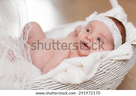 Cute newborn baby girl sleeping in basket, little girl new born baby smiling, portrait of 1 month baby girl, adorable kid in cozy accessories at home, soft focus, mother care concept, series