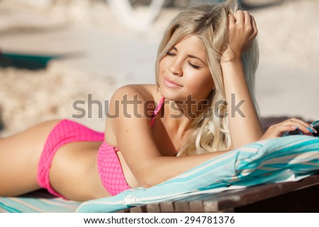 Beautiful sexy girl at beach bikini woman at pool, glamour blonde female in swimsuit relaxing at beach, vogue style model in swimwear, happy lady summer vacation portrait, girl in pink bikini outdoors
