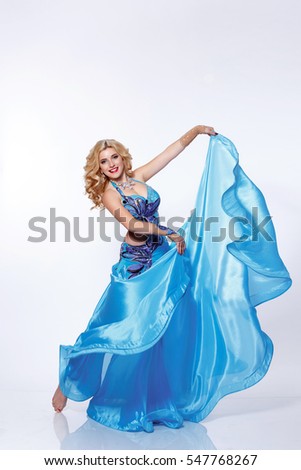 Beautiful Arabic Belly Dancer Harem Woman In Blue Dress And Jewelry Dancing Arms In Air Beautiful Arabic Belly Dancer Harem Woman In Blue Dress And Jewelry Dancing Arms In Air