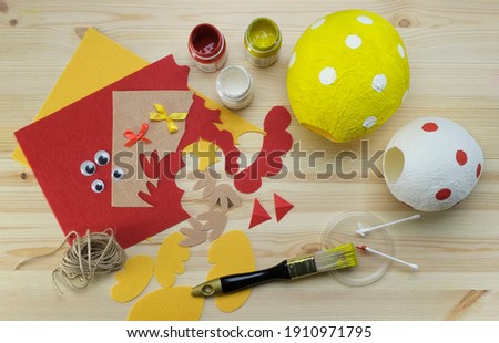 Step by step instruction handmade craft. DIY cute chicken and cockerel for Easter. Step 7 of 9. Color the paper casings and leave to dry. Stockfoto © 