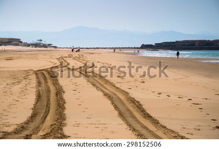 TARIFA, SPAIN MAY 19, 2015: Tracks on the almost empty beach. Trace of a car or tractor on a Tarifa main beach. Golden sand, not many people. Preparing beach for a tourist season.