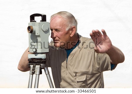 The man is looking through optical instrument