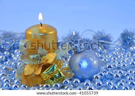 Golden burning candle and silver ball with Christmas decorations