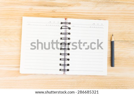 Blank open notebook with black pencil on wood table,Business template mock up for adding your text