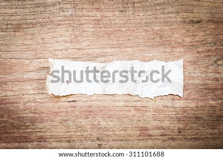 Close up view of torn piece of old paper for massage on wood background