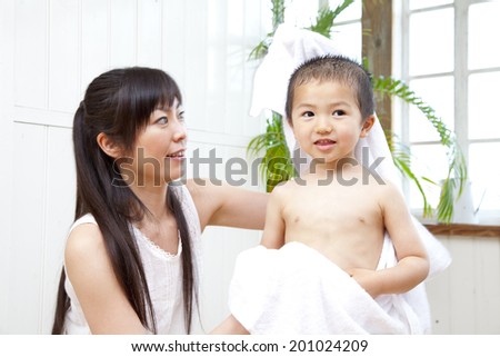 Mother wiping the body of her son with a towel