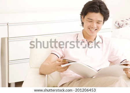 The man reading a magazine on a chair