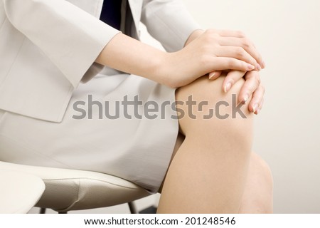Business woman that cross-legged sit in a chair