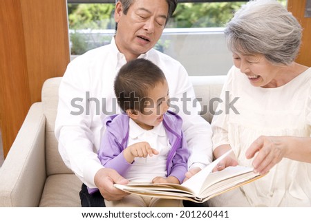 A grandma and granddad playing with grandson