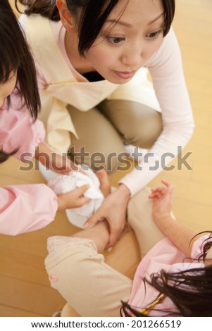 Kindergarten teachers wiping the feet of kindergarten girls
