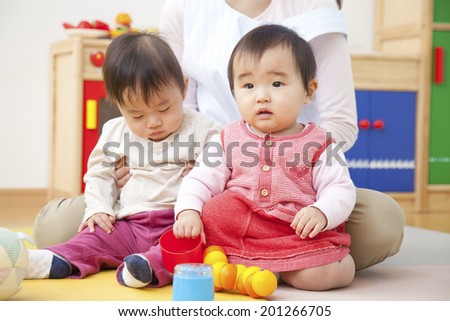 Nursery school children and nursery playing with toys