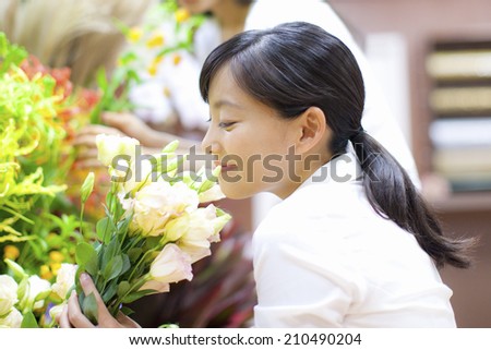 The female clerk in the flower shop and customers