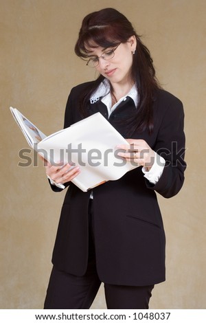 beautiful brunette in business suite reading book