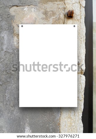 Single paper sheet with nails on cracked medieval stone wall