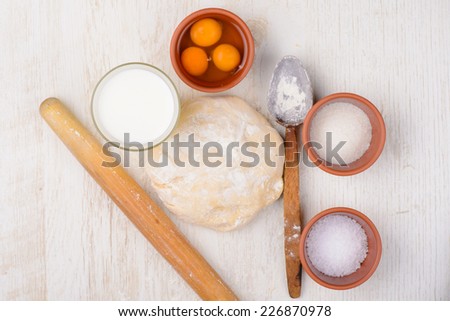 dough, flour, eggs, milk, salt, sugar, baking ingredients on a table