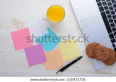 laptop on a table with cookies and a glass of juice