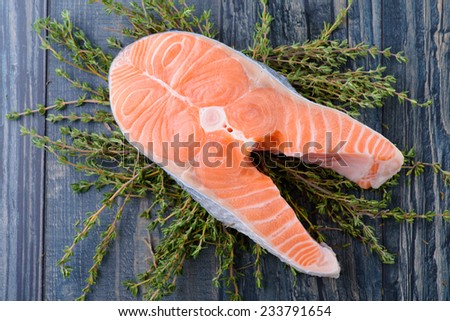 fresh salmon with thyme on a wooden board. closeup