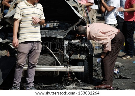 CAIRO - SEP 05: Members of CID search for evidences in an exploded car belongs to interior minister convoy after the explosion of a bomb was targeting the Minister. Cairo, Egypt on September 05, 2013