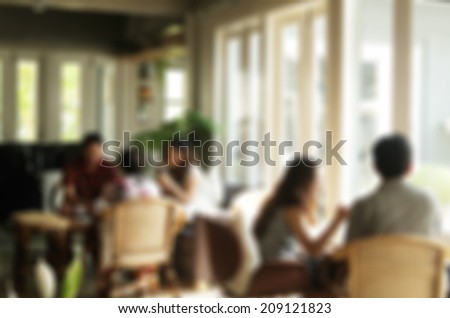 blurred silhouettes of sitting people in coffee cafe