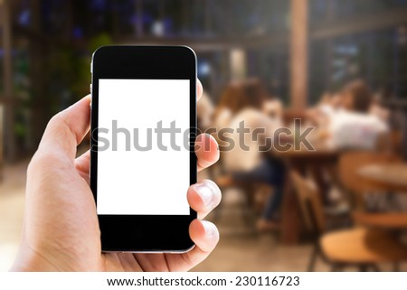 Close up hand holding smart phone with blank screen on people in restaurant background