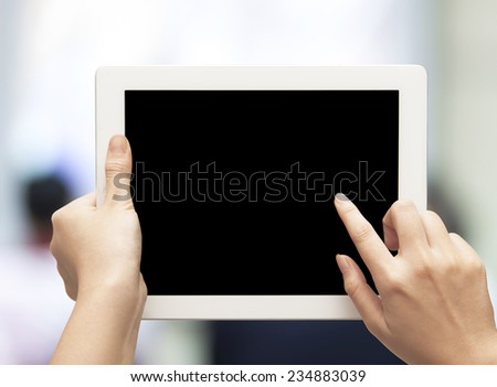 female teen hands using tablet pc with black screen on blurred people background