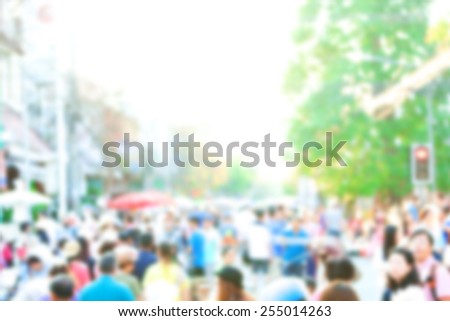 Crowd of anonymous people walking on busy Chiang Mai street, blurred people
