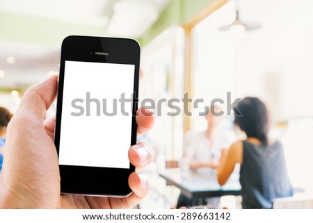 Close up hand holding smart phone blurred background of talking people in restaurant