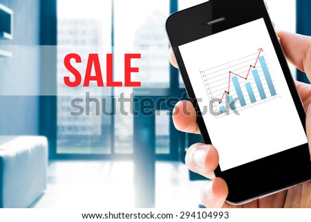 Closeup hand holding mobile phone show analyzing graph with conference room background ,sale word