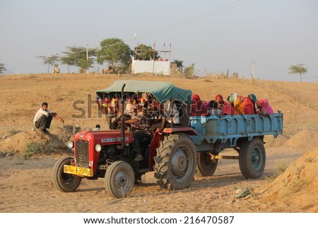 Pushkar, India, November 28, 2012: Indian People on a truck. Brightly colored sari\'s sitting in a farm trailer at the Pushkar Fair, Rajasthan, India