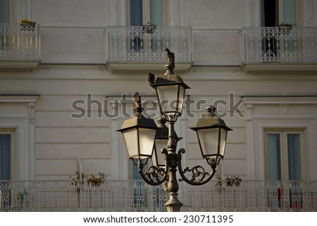 Amalfi, Italy, August 11 2014: Architectural detail of a street lamp, with pigeons on it